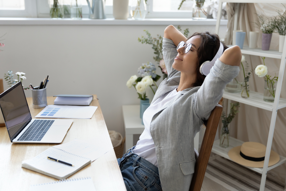 Woman relaxing in a home office listening to headphones
