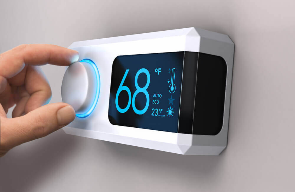 Hand changing thermostat setting to 68 degrees