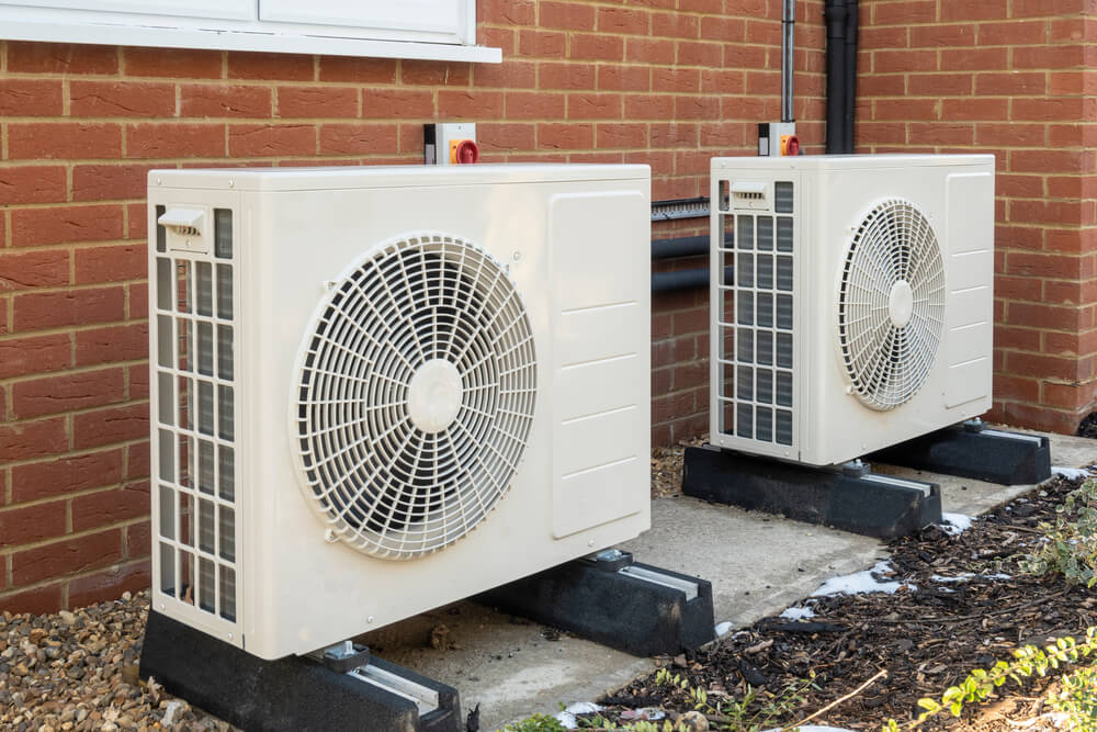 two heat pump systems outside of a brick building